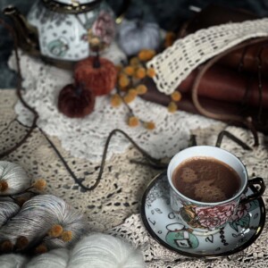 doilies with hot chocolate in a teacup with a teapot and fall decor